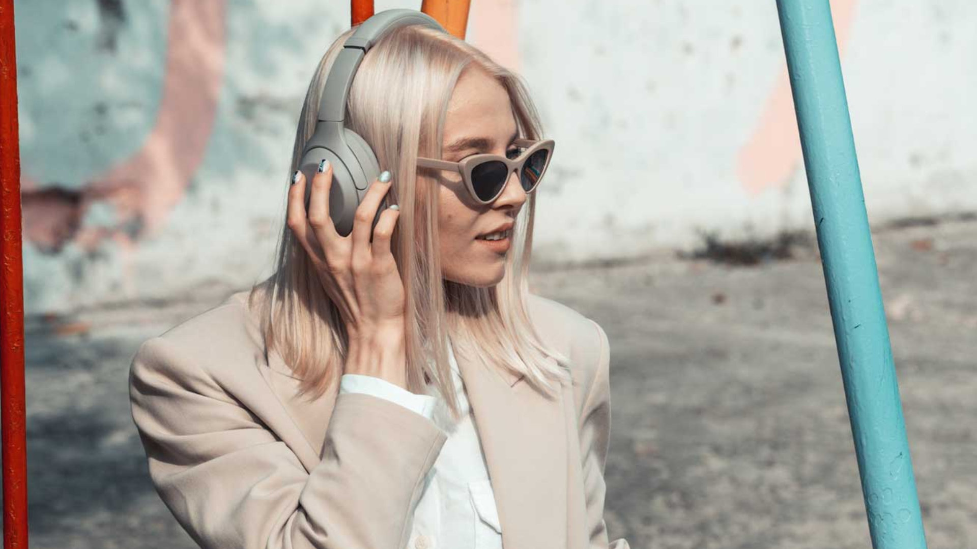Blondes Mädchen mit Kopfhörern beim Anhören eines Podcasts.