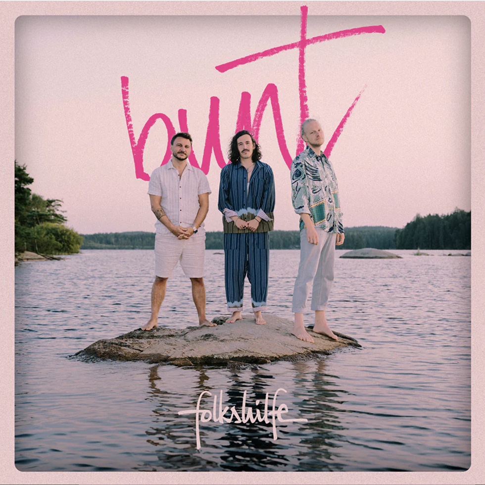 Folkshilfe: Neues Album bunt Albumcover: 3 Männer stehen auf einer Mini-Insel – alles mit einem Rosa-Schleiher