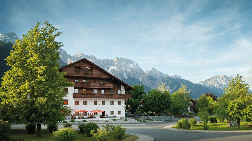 Hotel Stern: Ansicht von einem schönen Alpenhotel mit Holzbalkonen, im Hintergrund Berge.