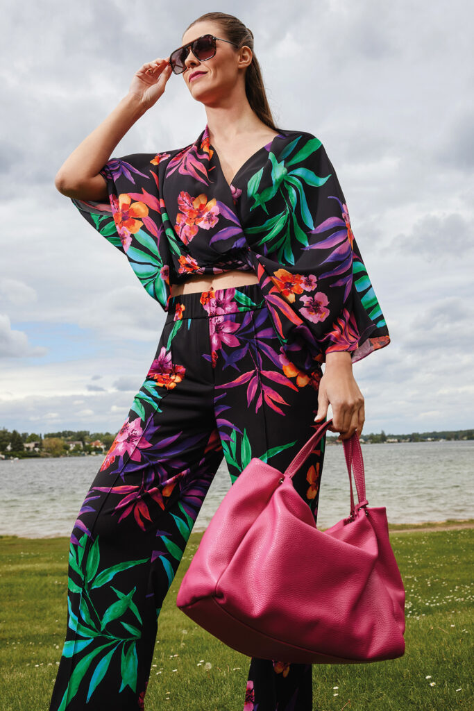 Sommermode: Frau in bunt-gemustertem 2-Teiler und pinker Tasche