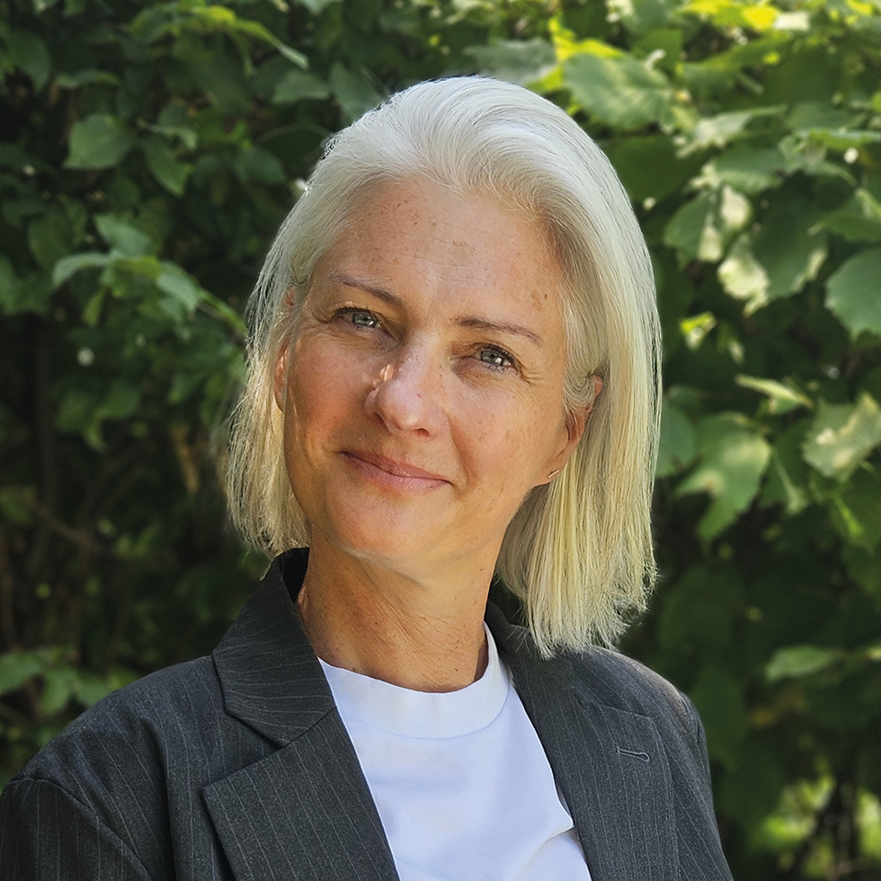 Top 100: Portrait einer hellblonden Frau mit grauem Blazer
