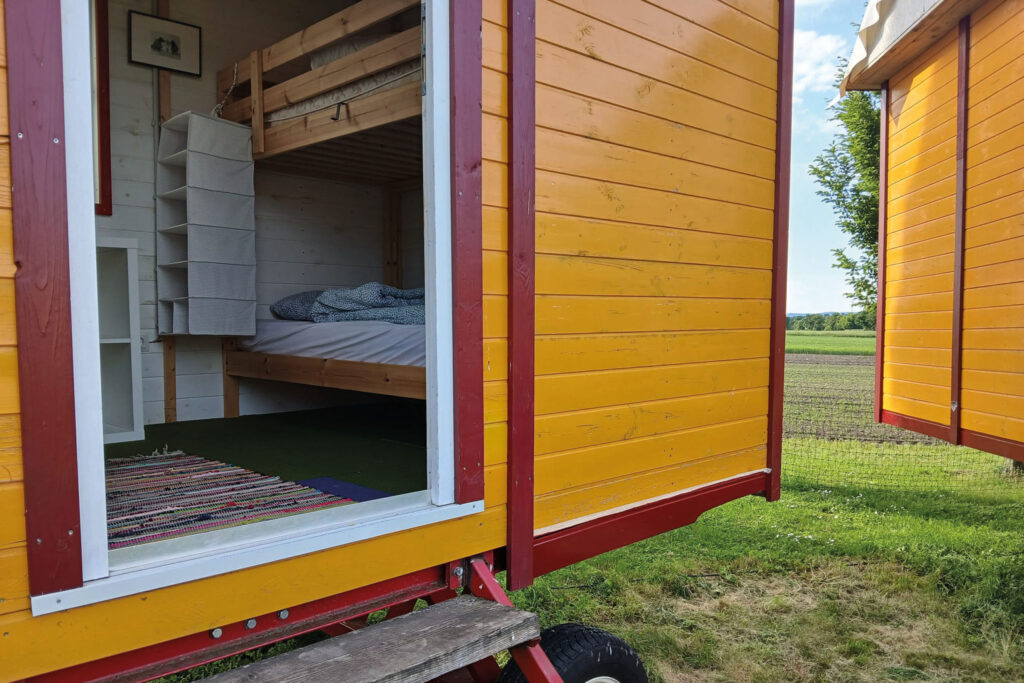 In einen gelben Wohnwagen hineinfotografiert – man sieht ein hölzernes Stockbett