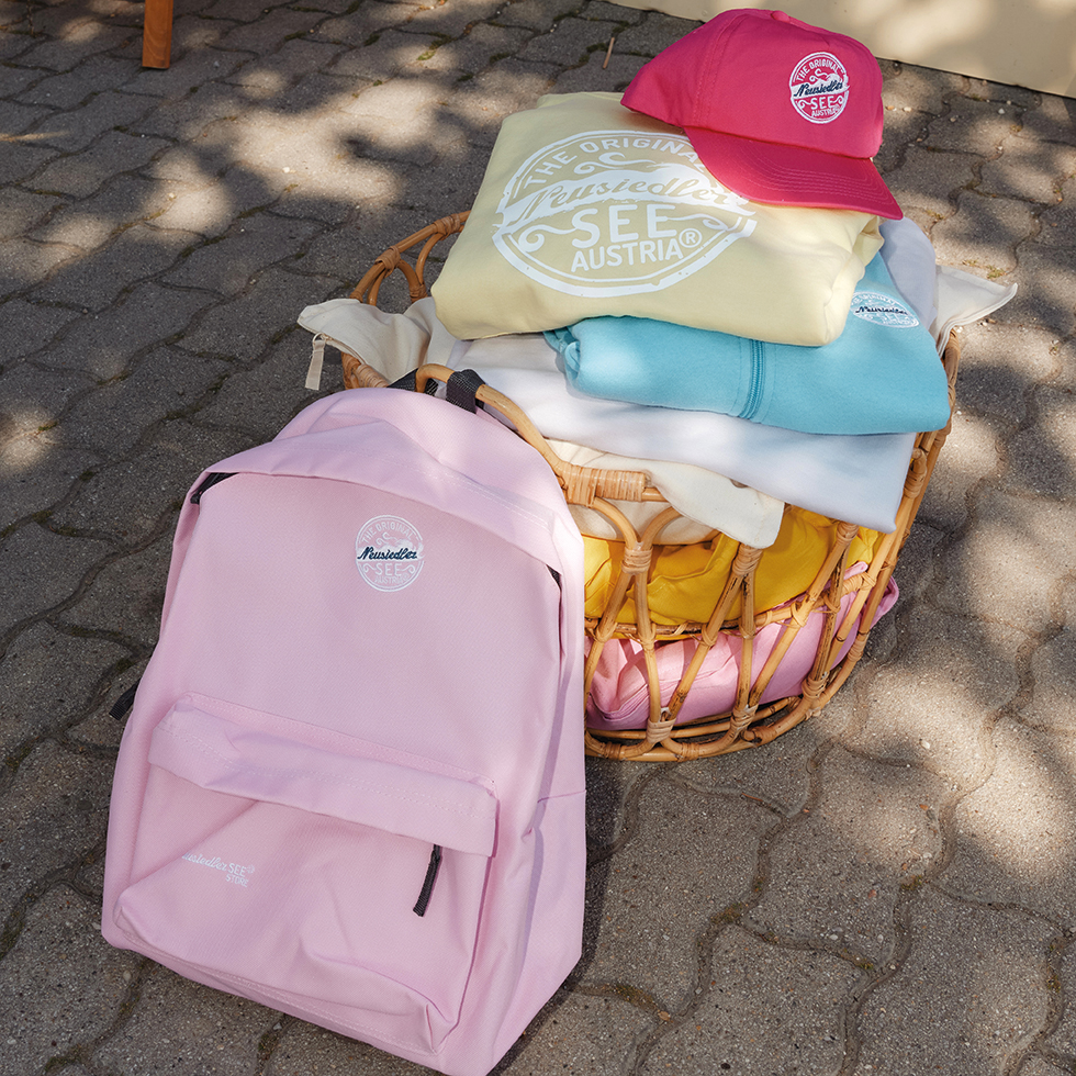 Rosa Rucksack, bunte Sweatshirts und eine rote Baseball-Kappe