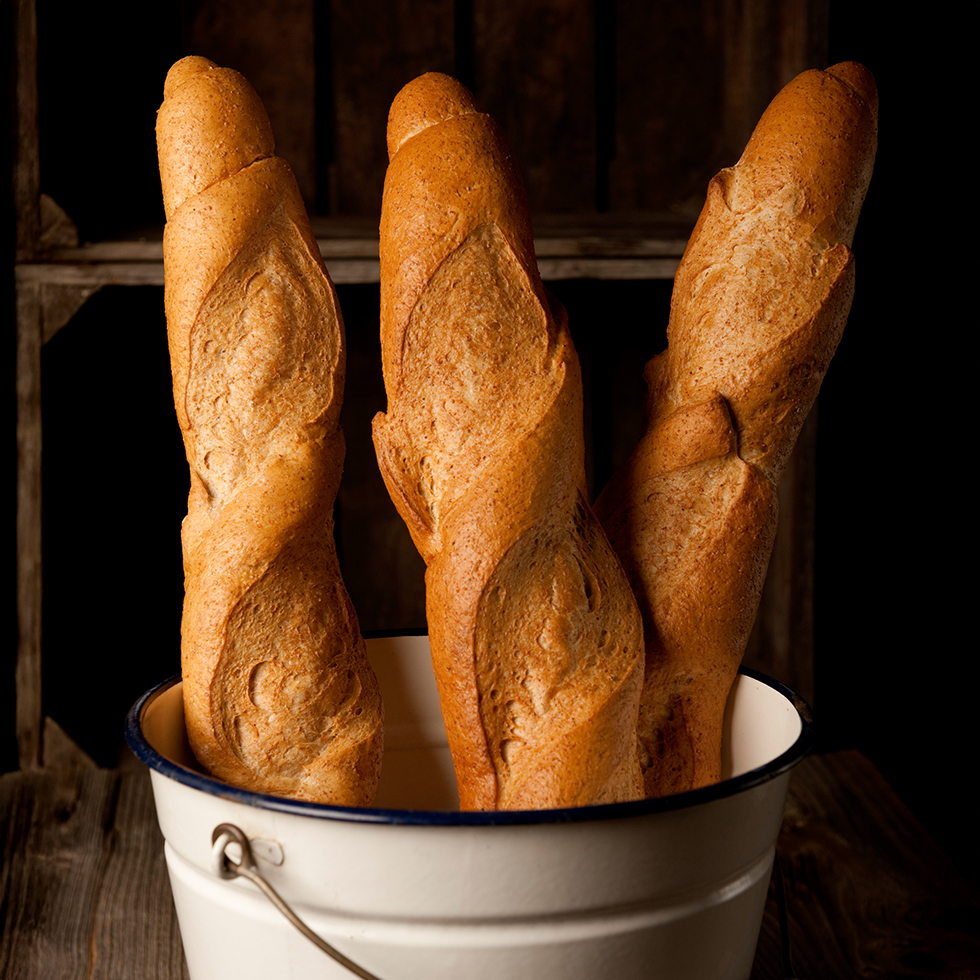 2 Vollkornbaguettes in einem weißen Emaille-Kübel
