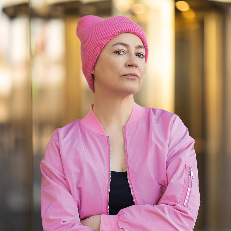 Frau mit pinker Muetze und pinker Bomberjacke schaut herablassend