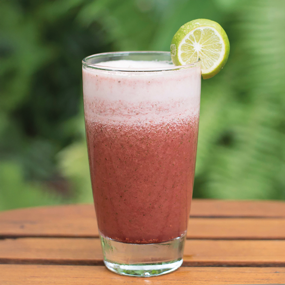Detox: Roter Smoothie im Glas mit weißem Schaum und Limettenscheibe.