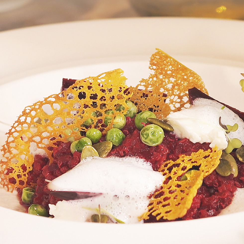 Rote Quinoa mit Erbsen, Schaum und knusprigem Dekor aus gelbem Teig.