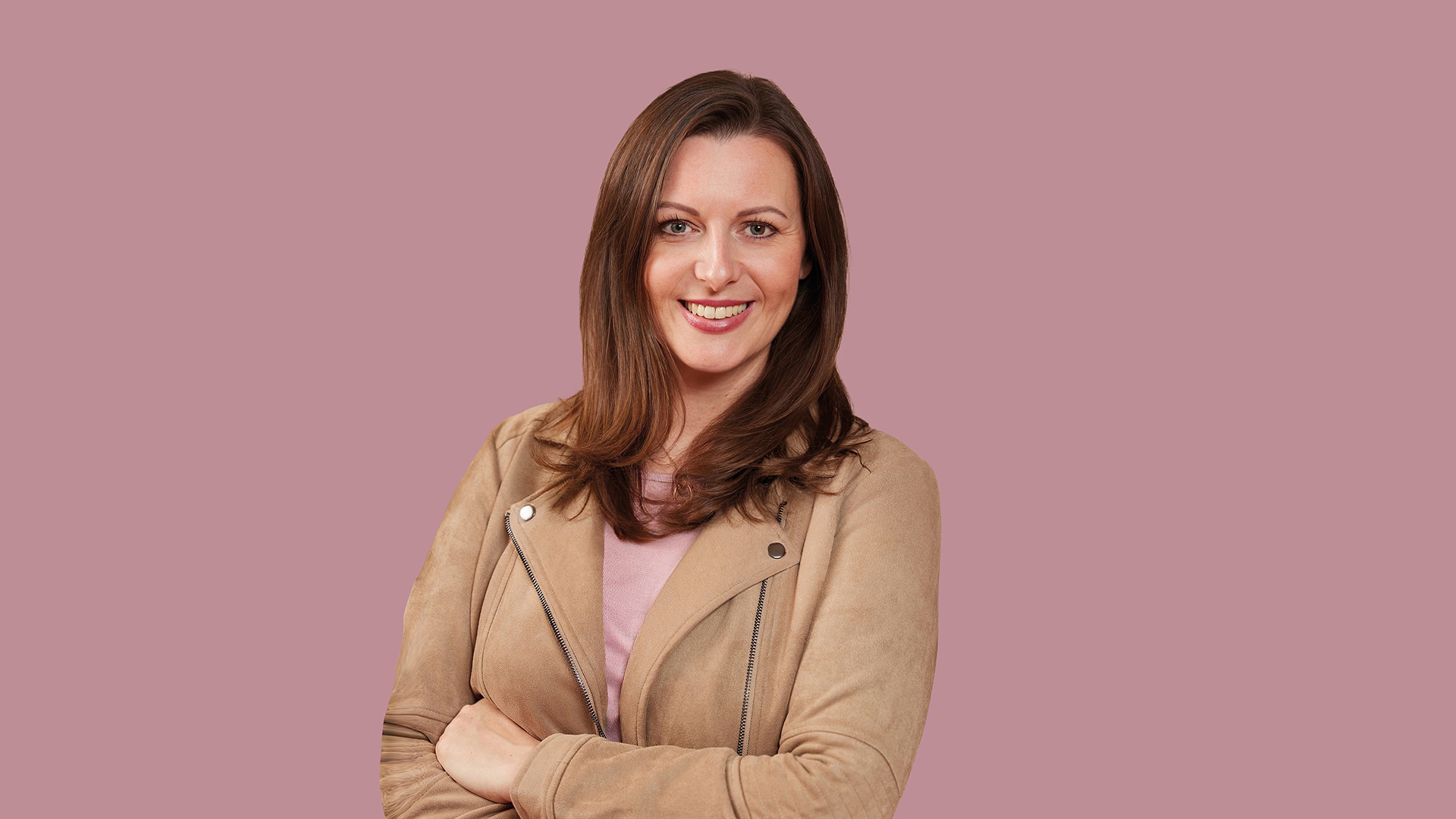 Frau in hellbrauner Lederjacke auf rosa Hintergrund