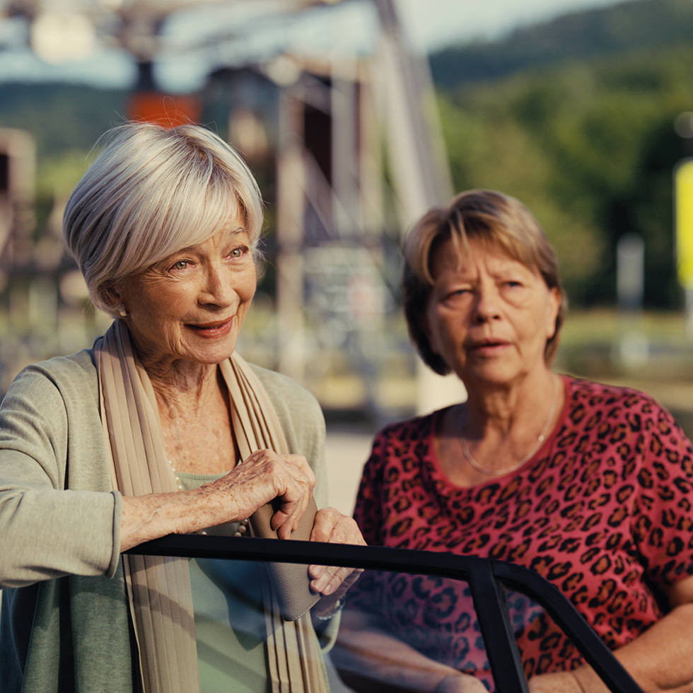 Zwei ältere Frauen im Freien im Gespräch bei sonnigem Wetter