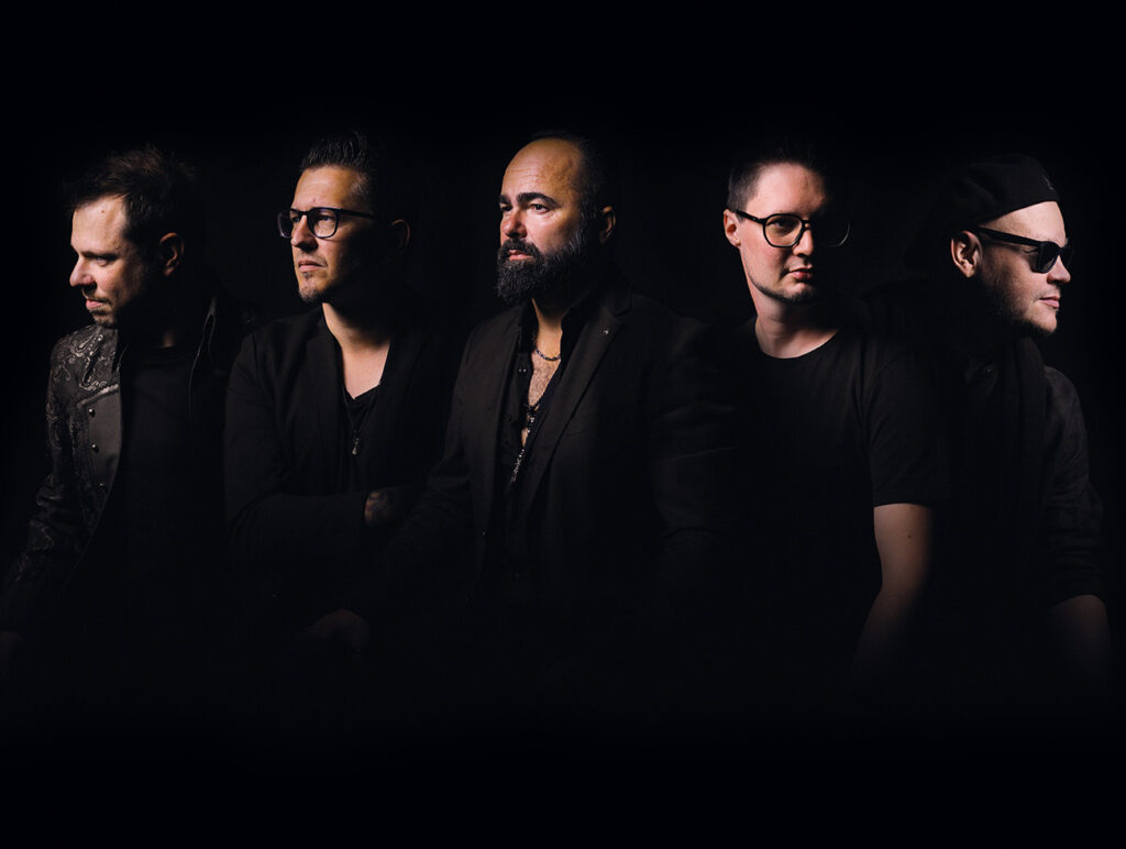 Kultur-Highlights im November: Fünf Männer in dunkler Kleidung posieren im Studio vor schwarzem Hintergrund