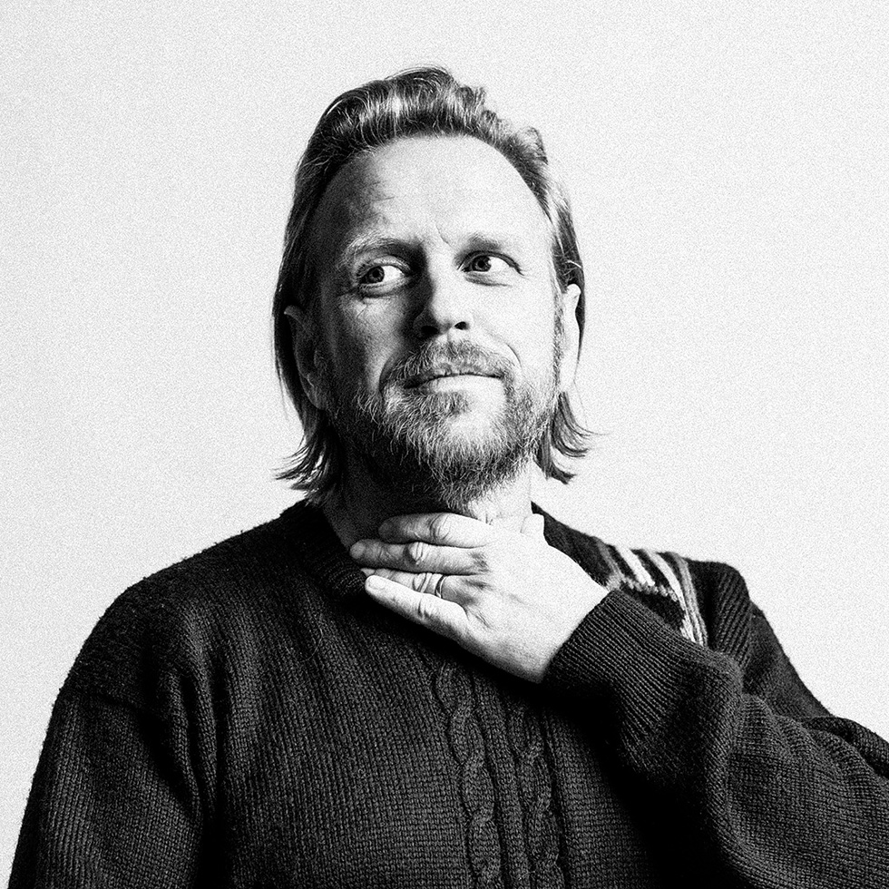 Schwarzweißporträt eines Mannes mit Bart, der nachdenklich in die Ferne blickt