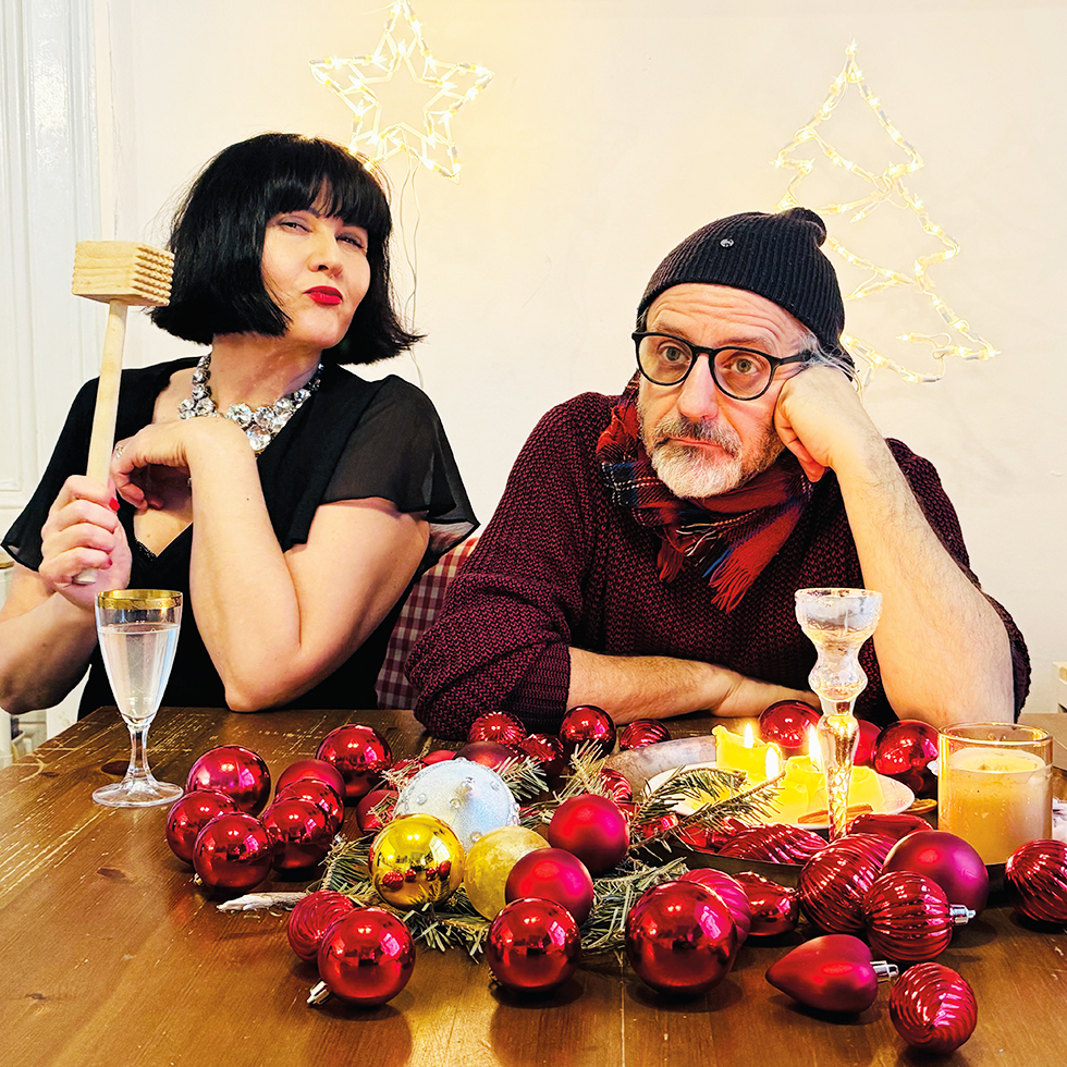 Kultur-Highlights im November: Mann und Frau sitzen an weihnachtlich geschmücktem Tisch mit Lichterdeko