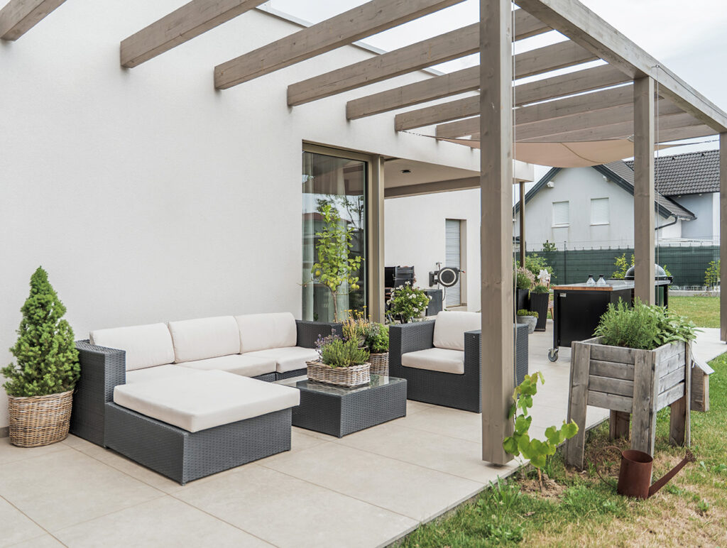 baderbau: Überdachte Terrasse mit Lounge-Sitzmöbeln und Pflanzen