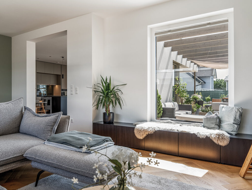 Helles Wohnzimmer mit gemütlicher Sitzecke und großem Fenster zur Terrasse