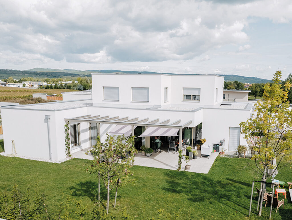 baderbau: Neubau mit Flachdach, Terrasse und gepflegtem Garten