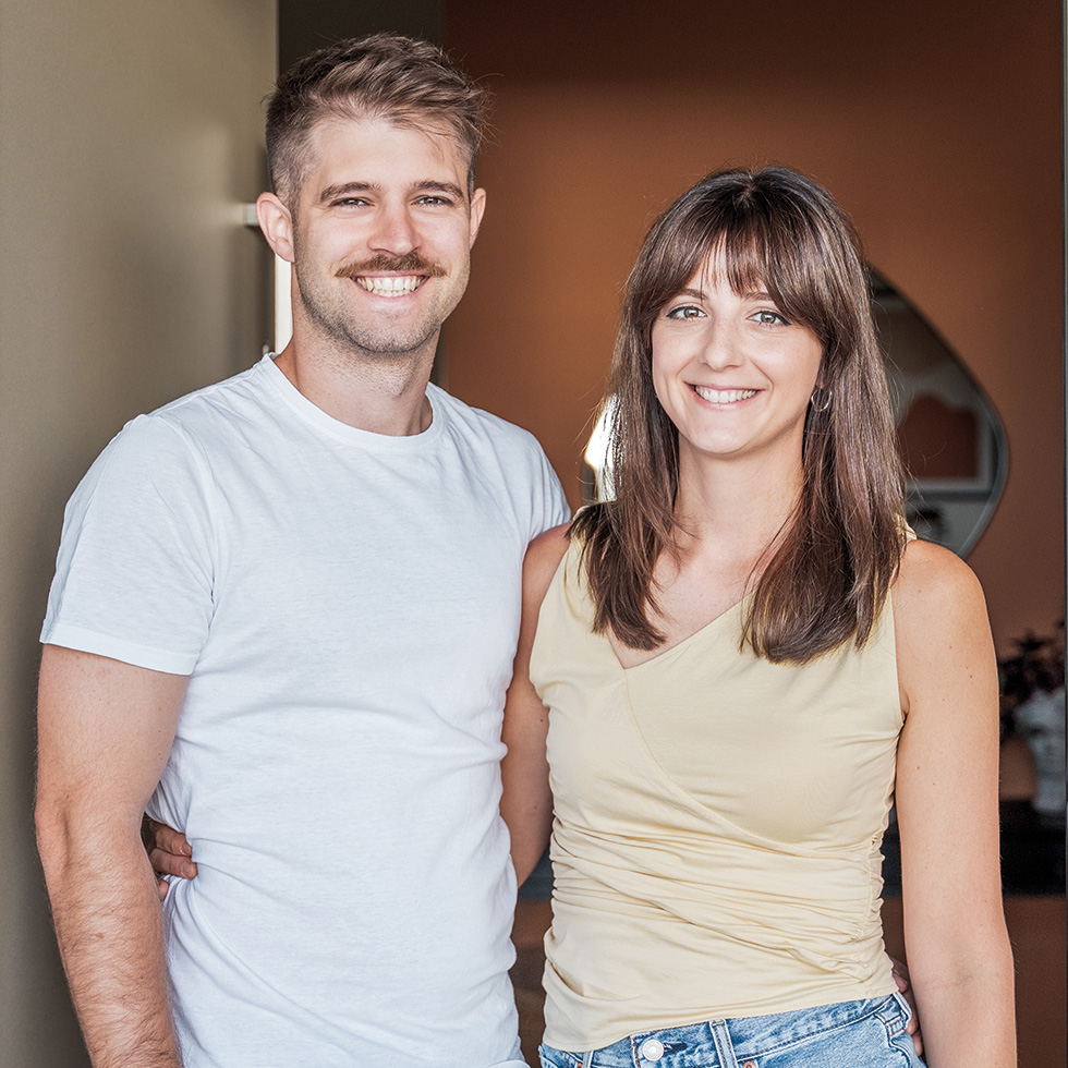 baderbau: unges Paar steht gemeinsam lächelnd im modernen Eigenheim