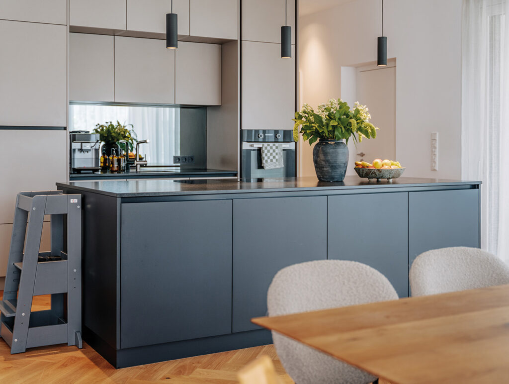 Moderne Einbauküche mit Kochinsel, Hängelampen und Dekoration