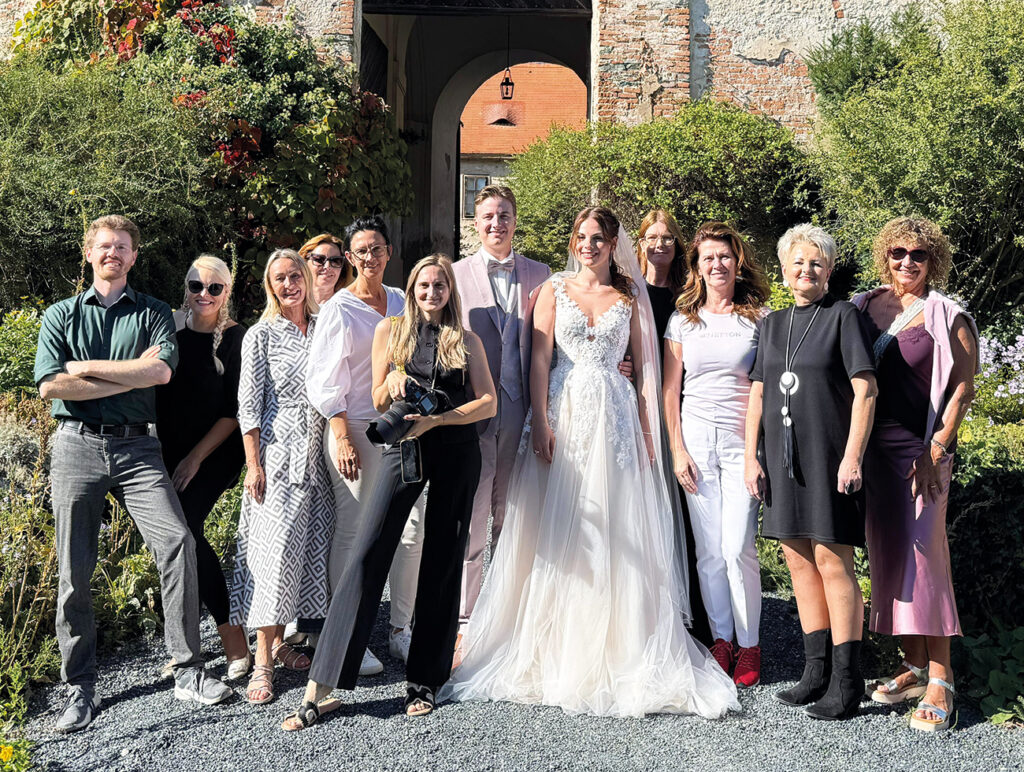 Gruppenfoto beim Hochzeitsshooting mit Brautpaar und Team im Schlossgarten