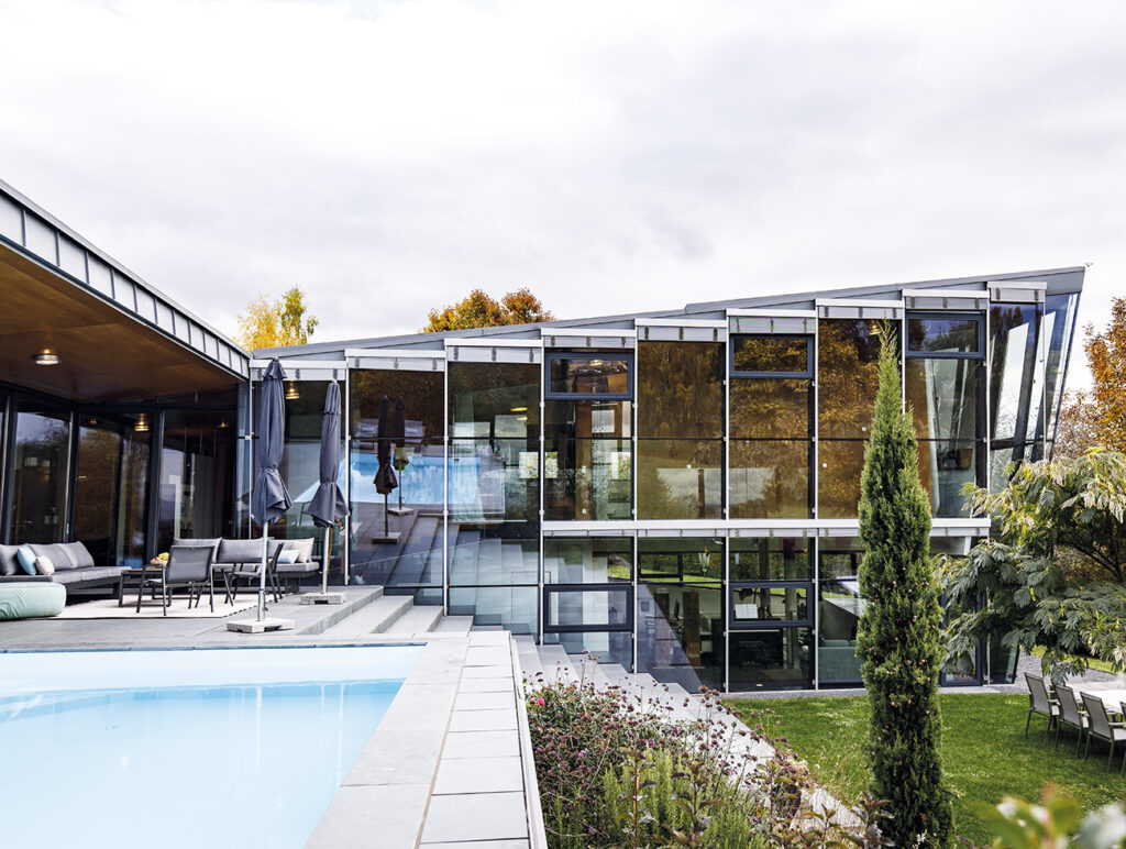 Villa: Glasfassade und Poolterrasse eines modernen Einfamilienhauses