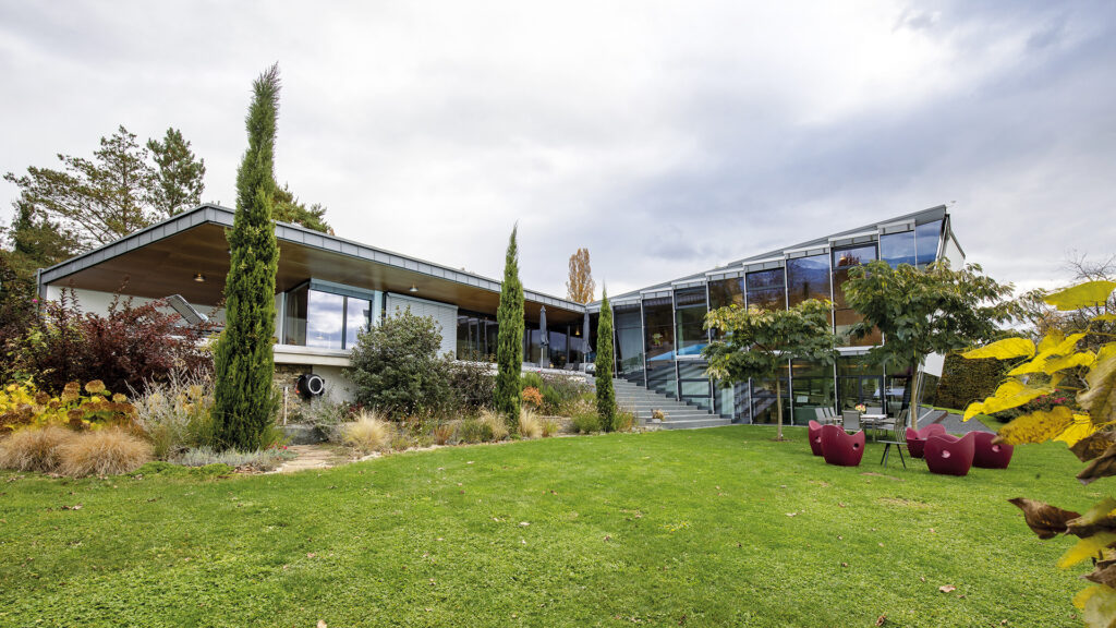 Villa: Außenansicht eines modernen Hauses mit Glasfronten und Garten