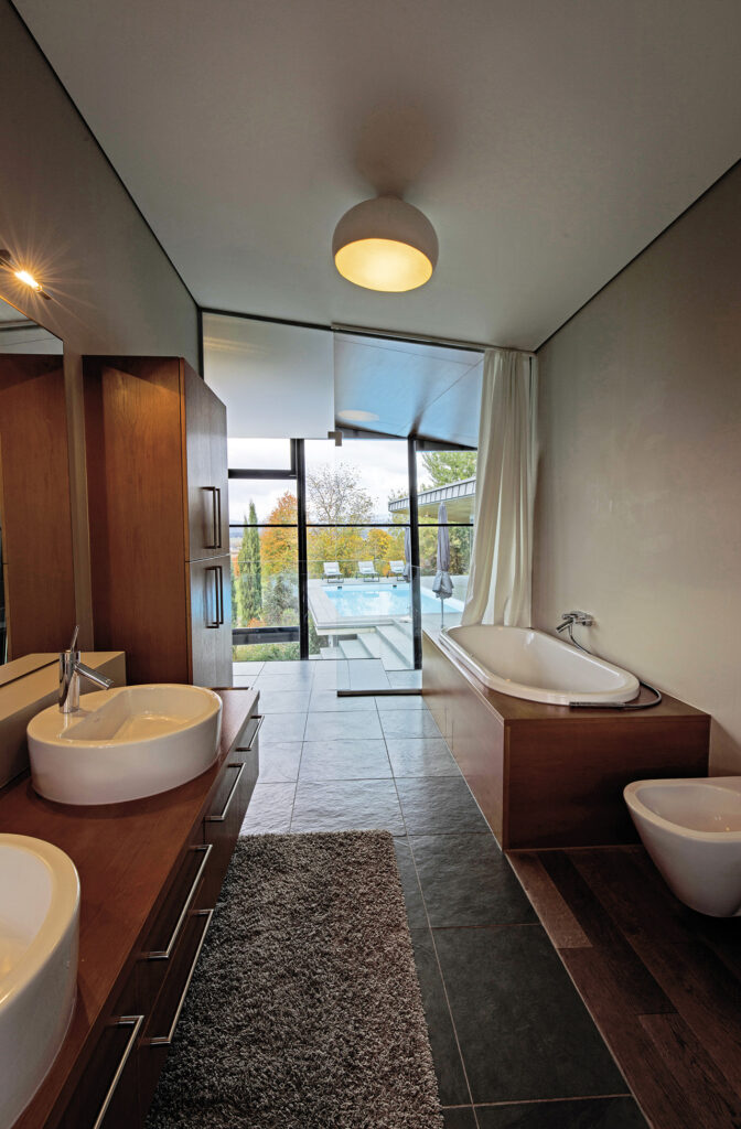 Villa: Modernes Badezimmer mit Badewanne, Doppelwaschbecken und Glasfront