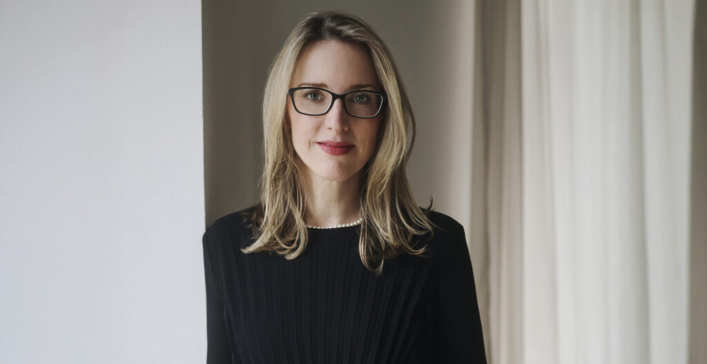 Alena Buyx Medizinethik: Frau mit blonden Haaren und schwarzem Kleid steht vor hellem Hintergrund.