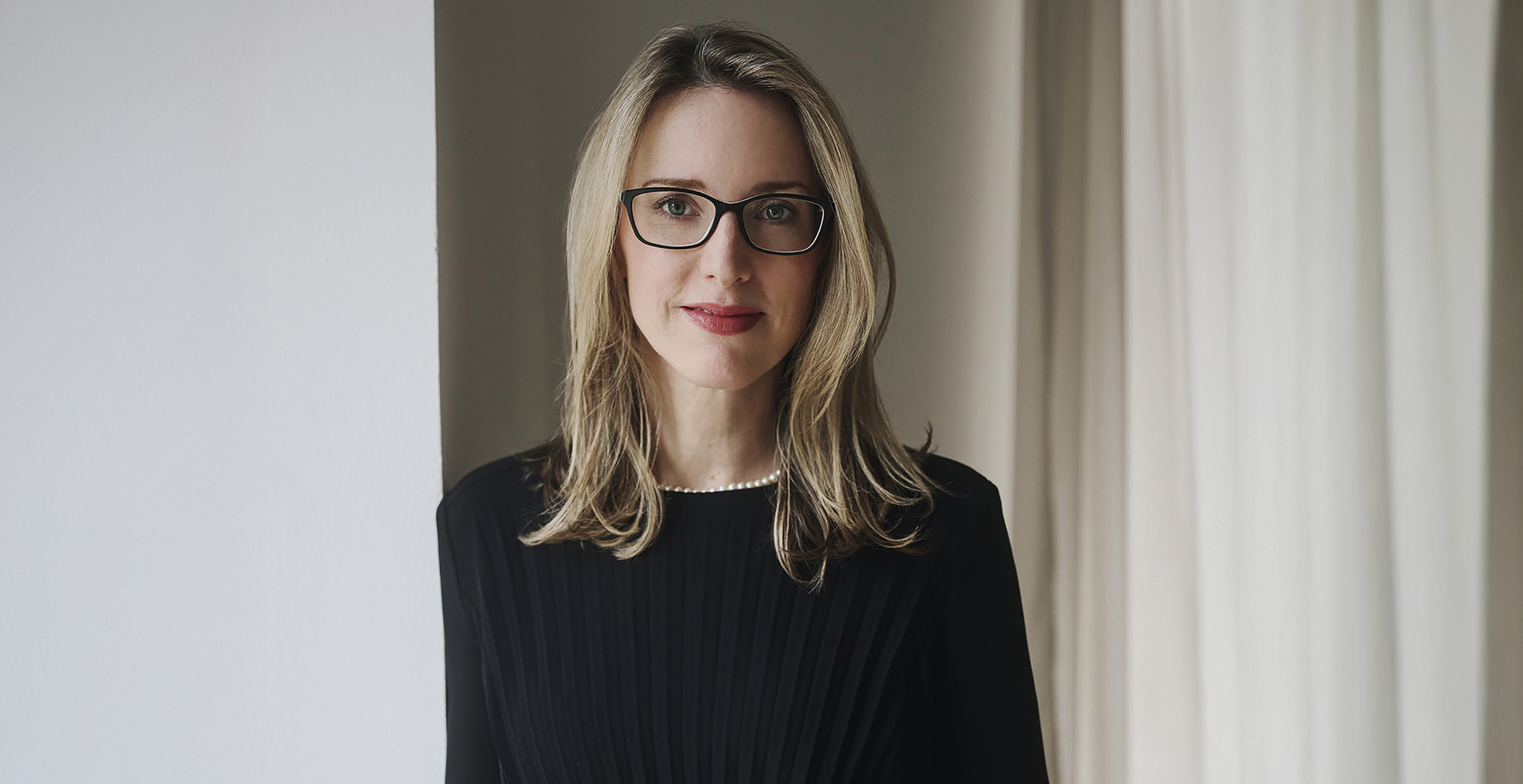 Alena Buyx Medizinethik: Frau mit blonden Haaren und schwarzem Kleid steht vor hellem Hintergrund.