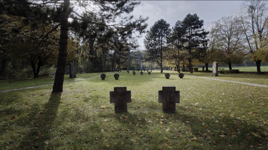 Kriegsgräber auf einem Baum-umgebenen Friedhof im Herbst