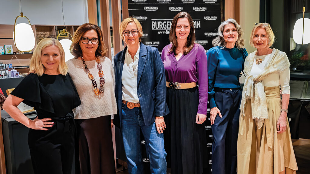 Podiumsdiskussion: Gruppenfoto der Podiumsteilnehmerinnen vor Veranstaltungsbanner