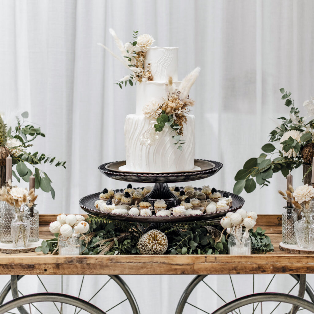 Hotel Nils: Eine Hochzeitstorte, die auf einem Wagen-Tisch mit großen Rädern präsentiert wird.