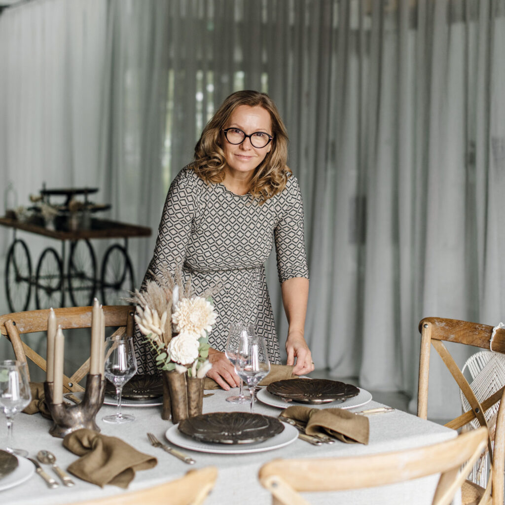 Eine Frau deckt einen Hochzeitstisch ein.