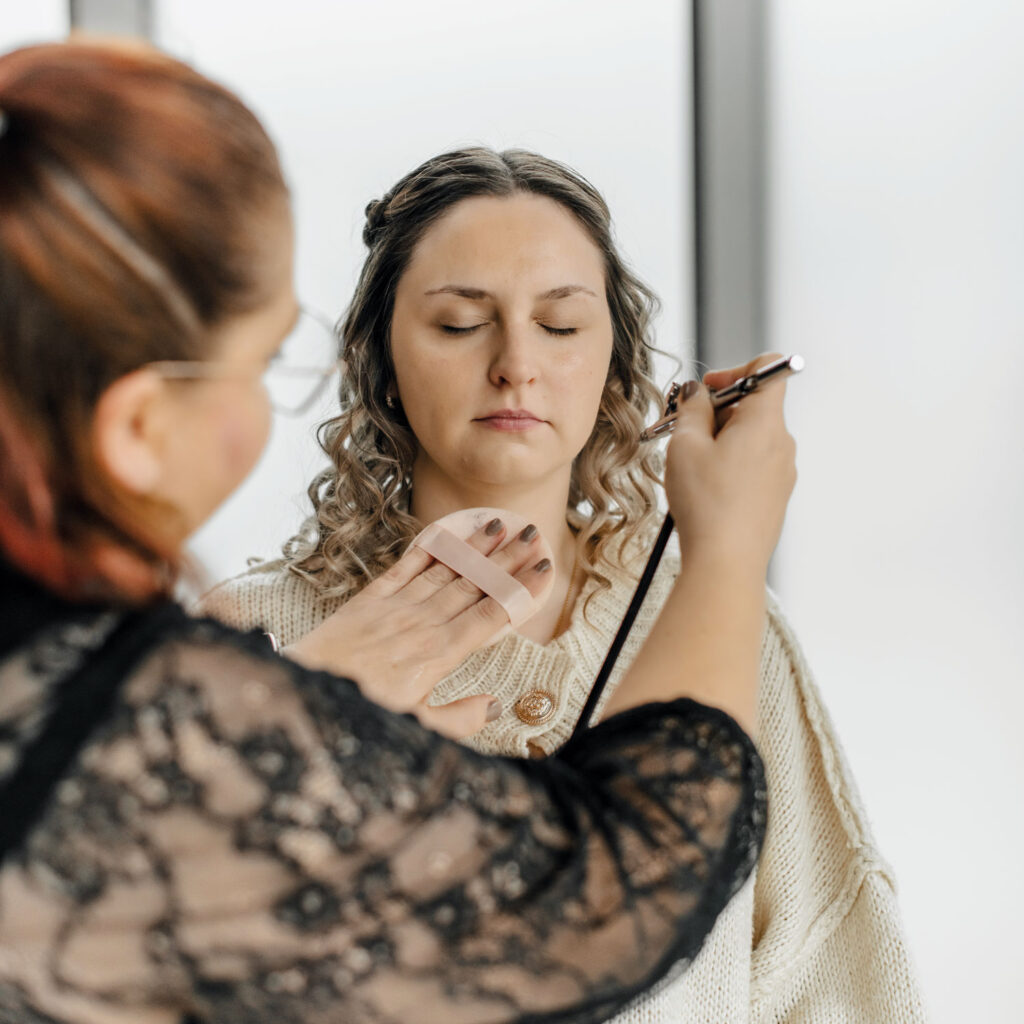 Eine Visagistin schminkt die Braut.