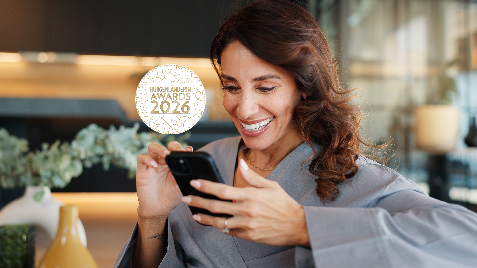 BURGENLÄNDERIN AWARDS 2026 Home, relax and woman with smile, cellphone and internet with message to contact, chatting and email. Apartment, mobile user and happy person on sofa, smartphone or funny meme with online joke or app