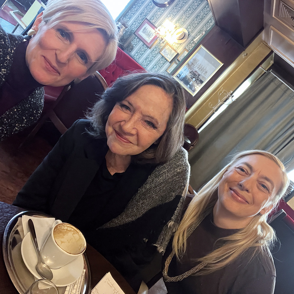 Maria Bill: Sitzt gemeinsam mit zwei Frauen in einem Café an einem Tisch.