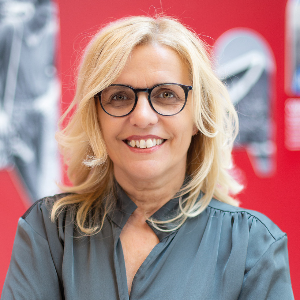 BURGENLÄNDERIN AWARDS VOTING: Portrait einer blonden Frau mit Brille auf rotem Hintergrund