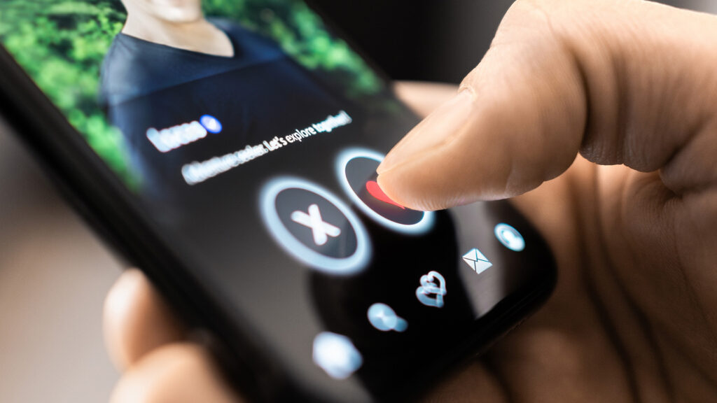 Dating-Apps: Man klickt auf ein Herz auf einem Mobiltelefon-Display – auf einer Dating-App-Seite