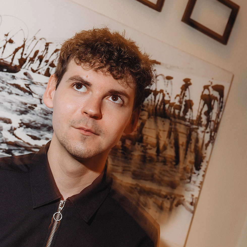 Michael Steiger in nachdenklicher Pose vor einem Kunstwerk.