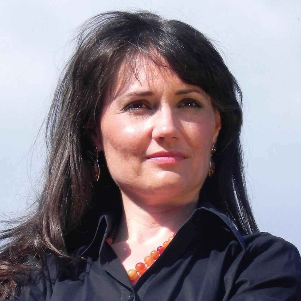 BURGENLÄNDERIN AWARDS VOTING: Portrait einer Frau mit Weitblick und langen dunklen Haaren, dunkelblauer Bluse und Bernstein-Kette