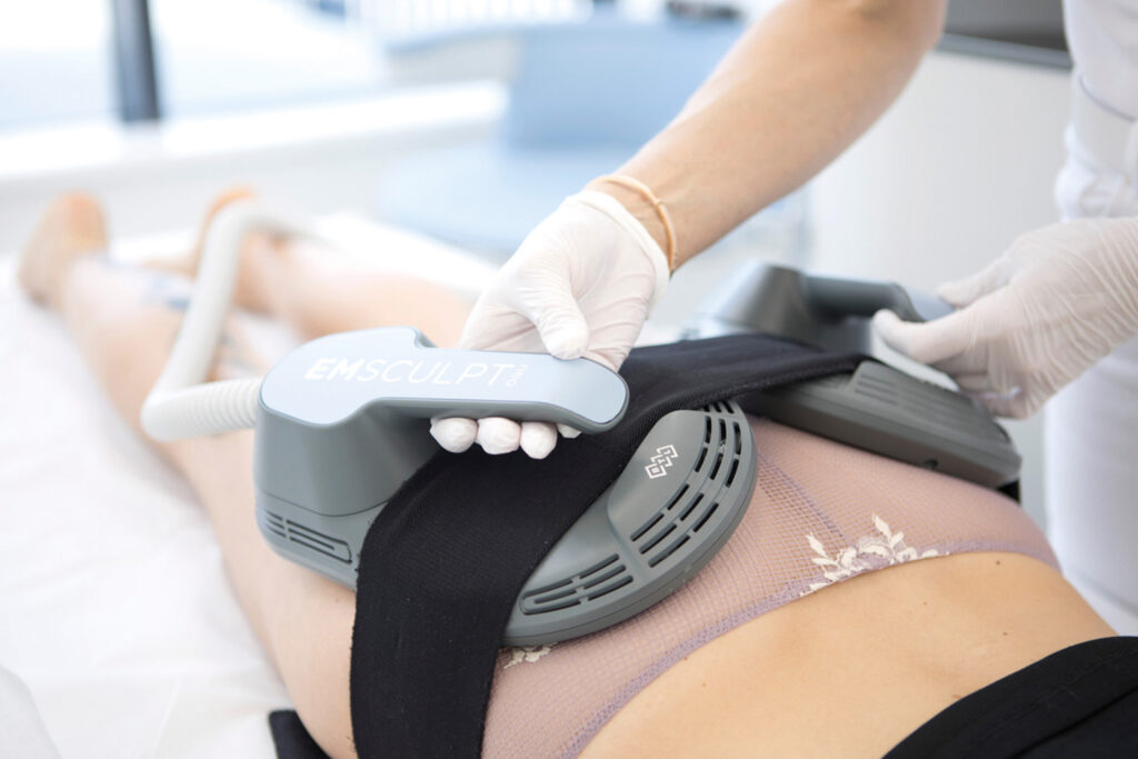 Coolsculptin: Ästhetische Körperbehandlung mit EMSCULPT-Gerät am Bauch.