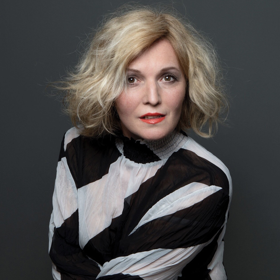 Frau mit blondem Haar im Studio vor dunklem Hintergrund