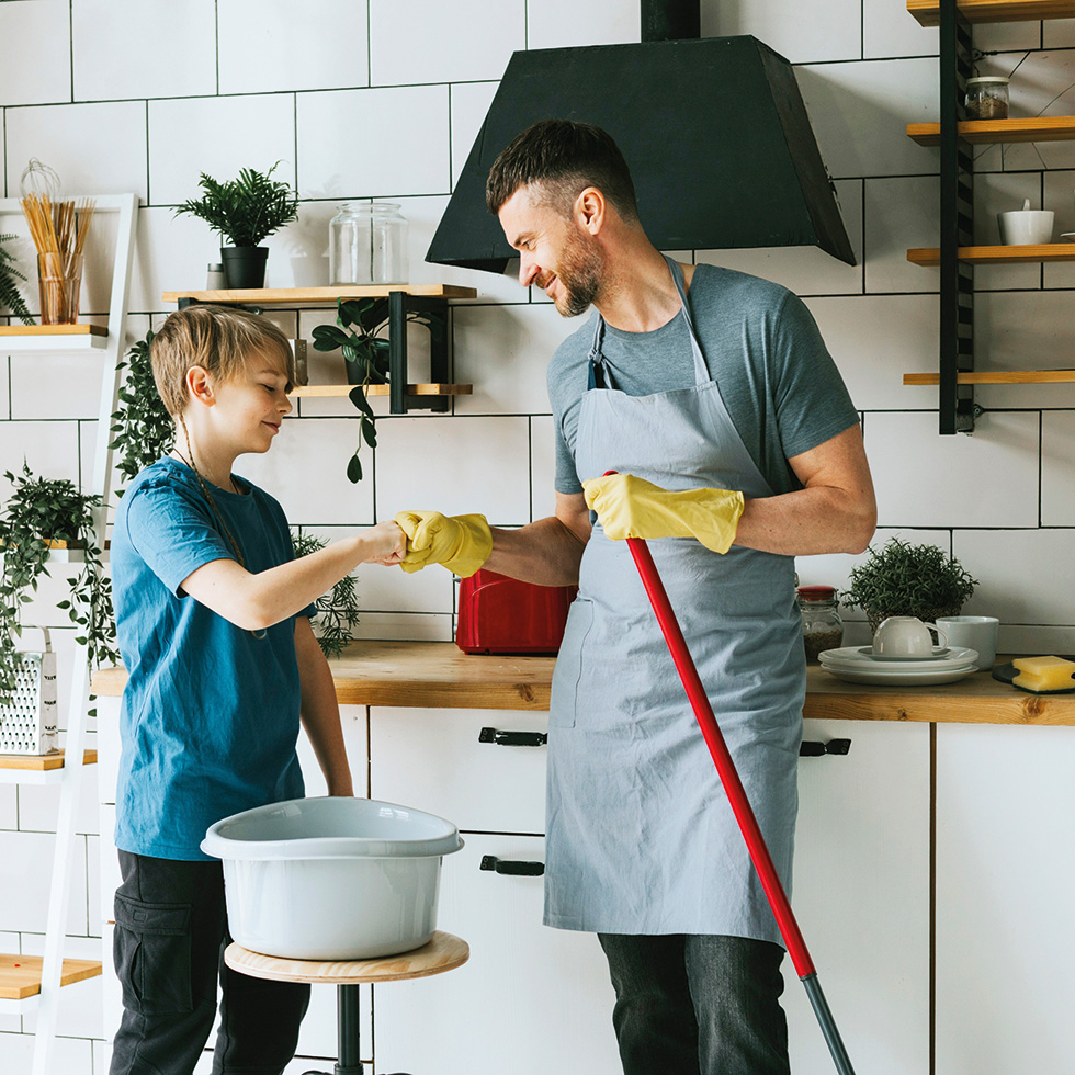Detoxmasculinity: Vater und Kind reinigen gemeinsam Küche, partnerschaftliche Care-Arbeit im Alltag