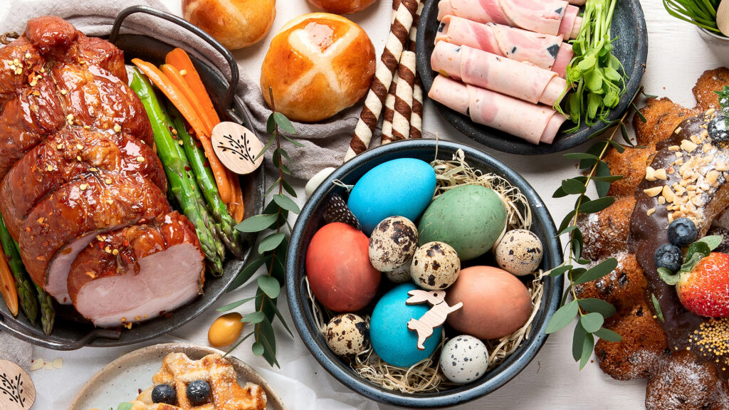 Ostern: Festlicher Osterbraten mit Gemüse, gefärbten Eiern und Gebäck