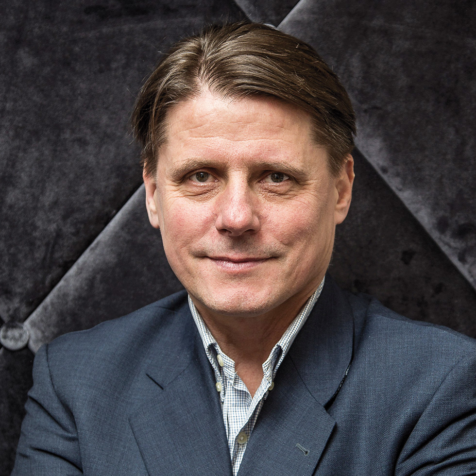 #bgld: Portrait eines Mannes im Anzug vor dunklem Hintergrund