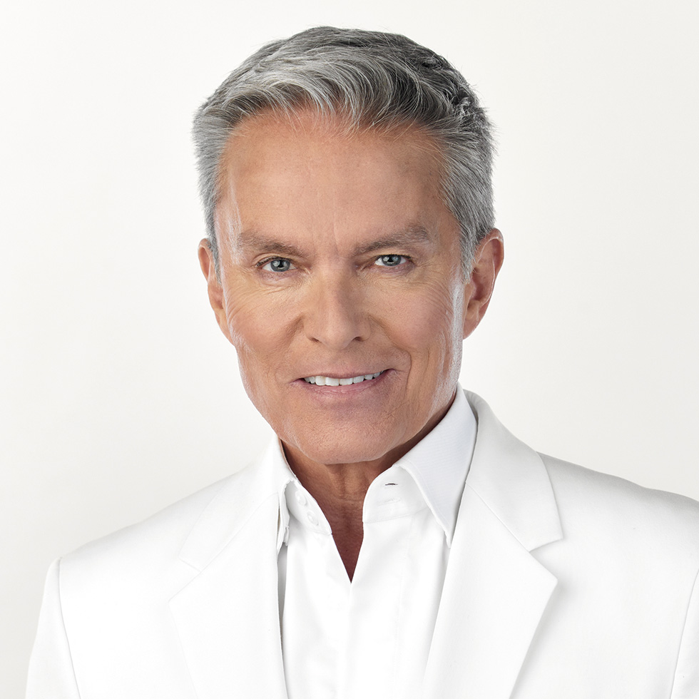 #bgld: Portrait eines Mannes im weißen Anzug vor hellem Hintergrund