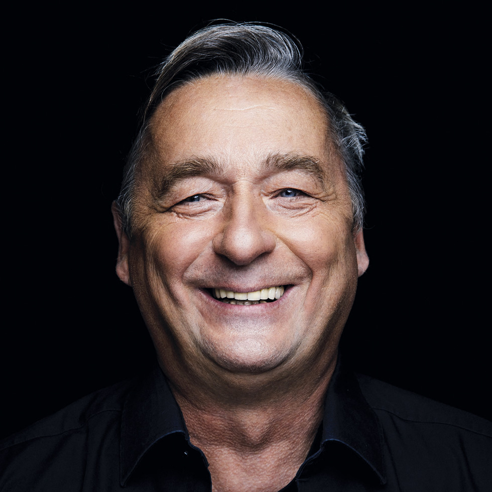 #bgld: Lachendes Portrait eines Mannes vor schwarzem Hintergrund