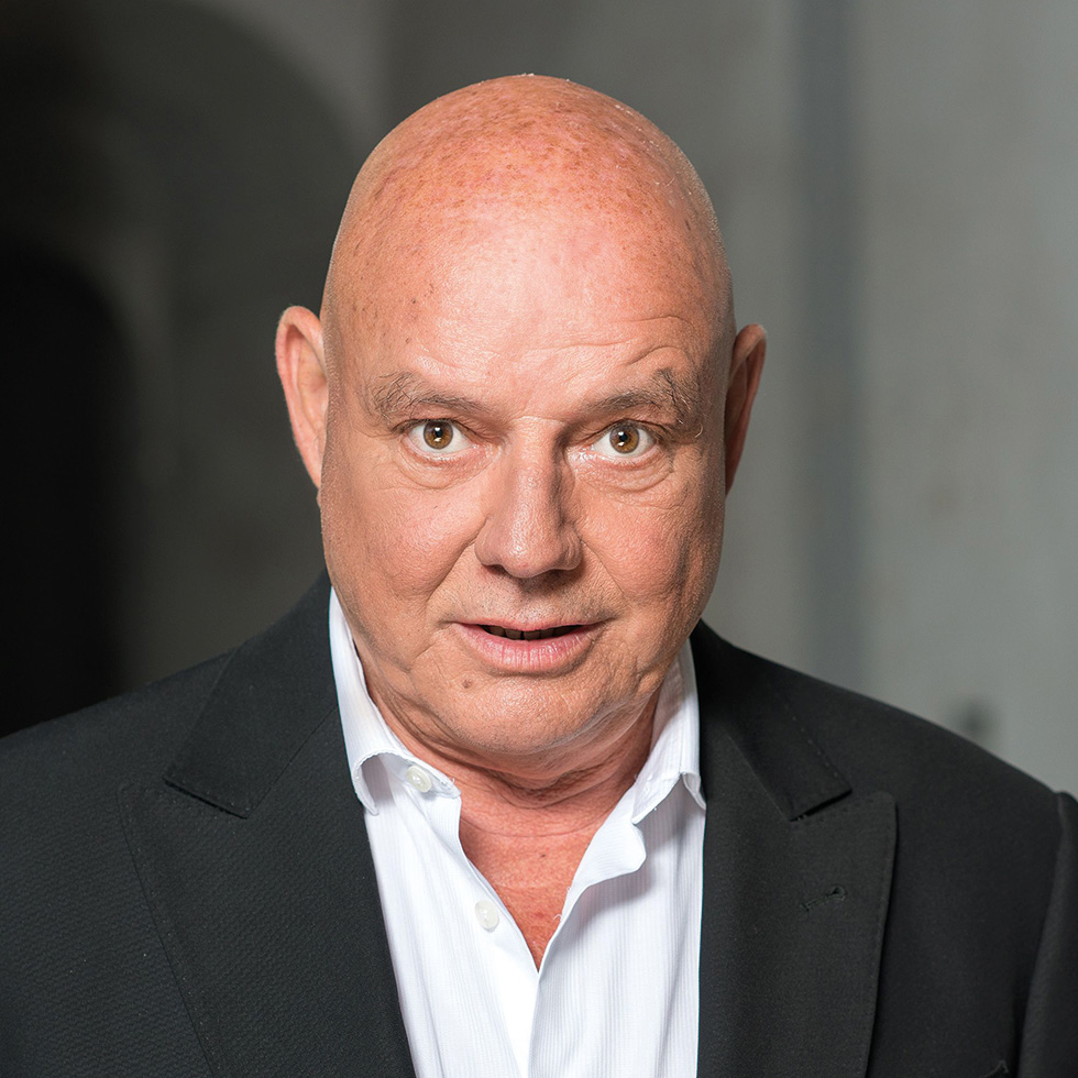 #bgld: Portrait eines Mannes mit Glatze im dunklen Sakko und weißem Hemd