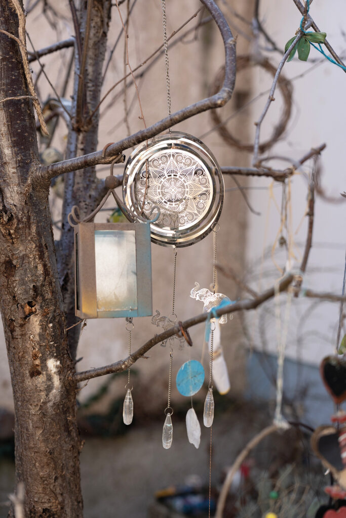 Dekoratives Windspiel hängt an einem Baum im Garten
