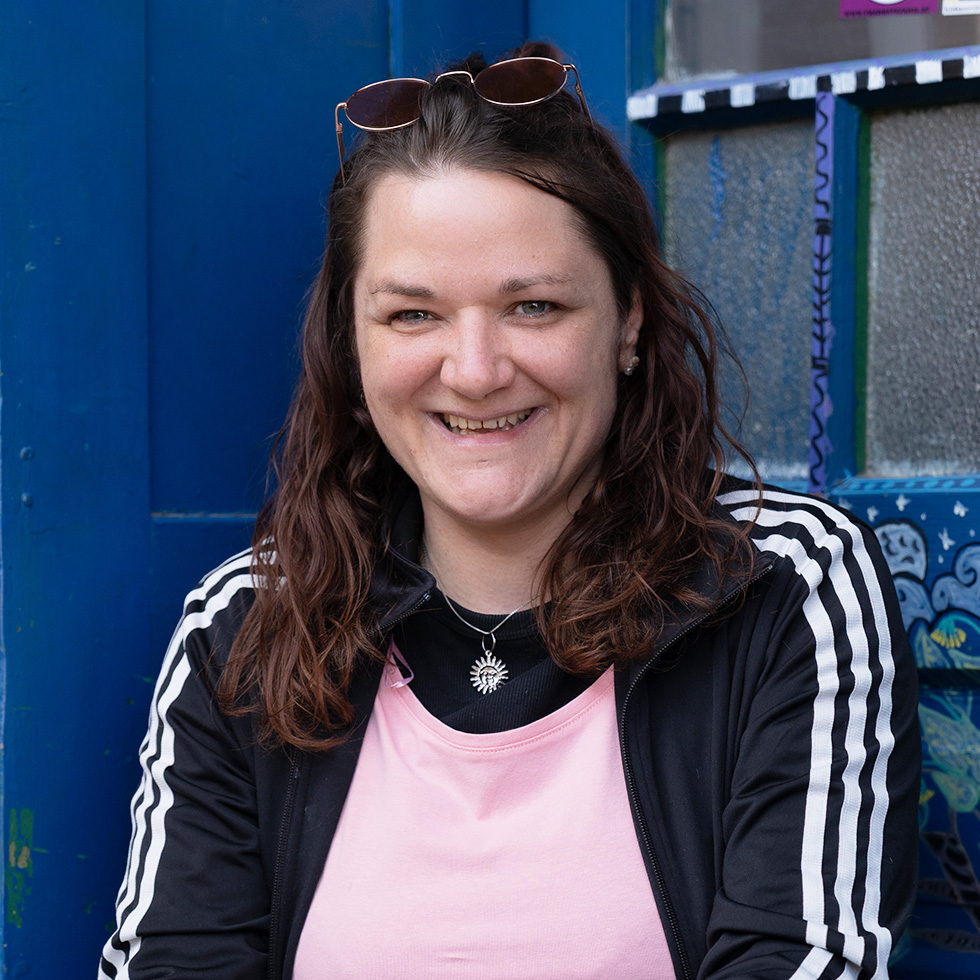 Mut: Porträt einer lächelnden Frau vor blauem Hintergrund