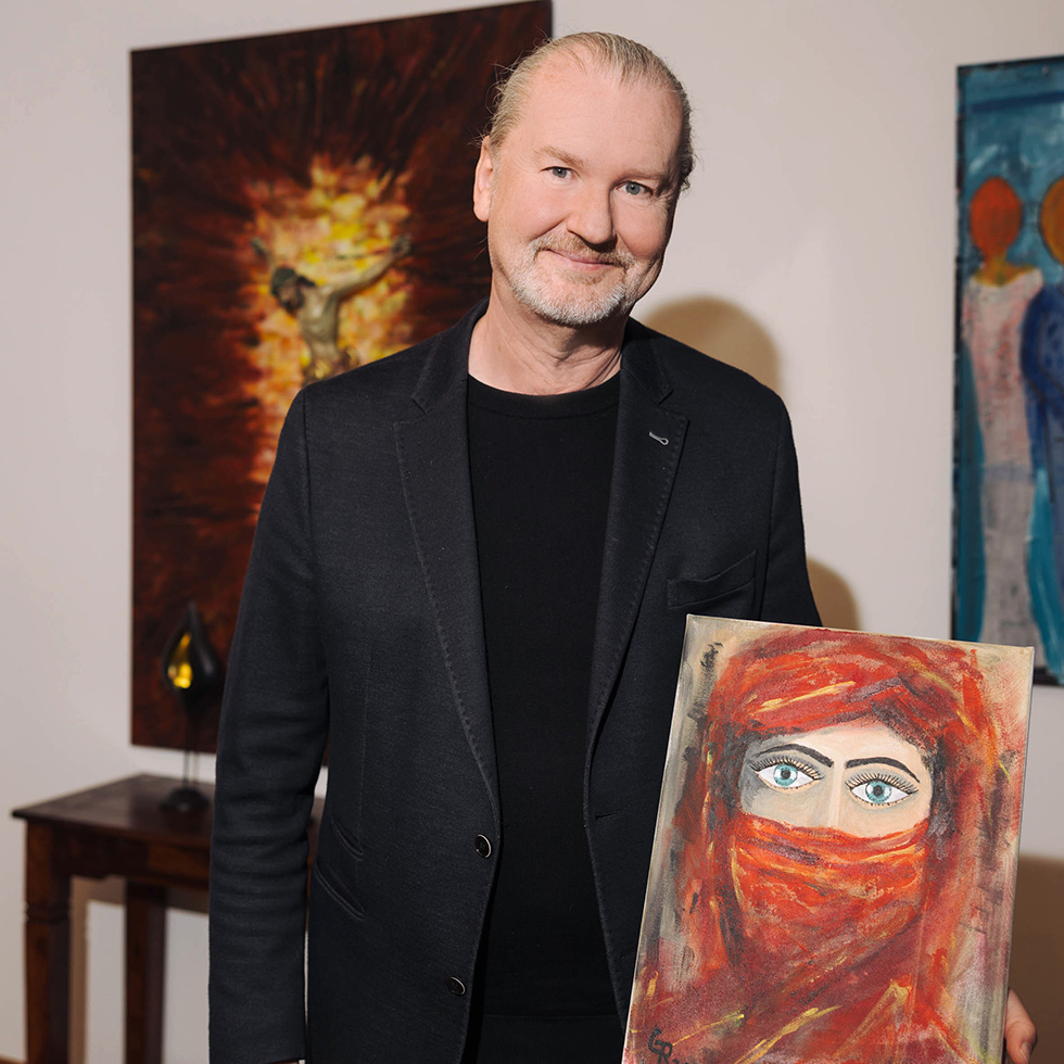 Passion: Mann hält ein Gemälde mit verhülltem Gesicht vor sich