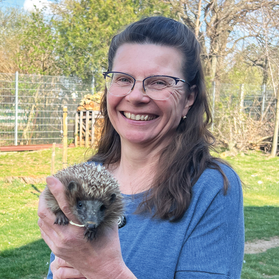 Tierheim: Frau hält Igel im Arm und lächelt in die Kamera